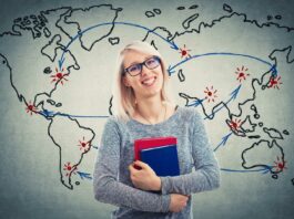 Joven estudiante sonriente mapa del mundo detrás