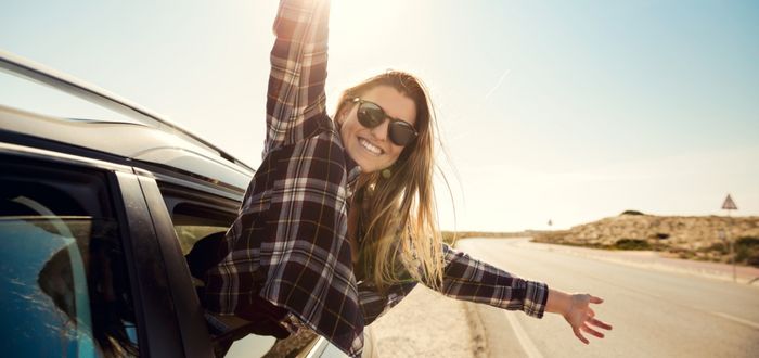 Mujer feliz en roadtrip | Beneficios de viajar