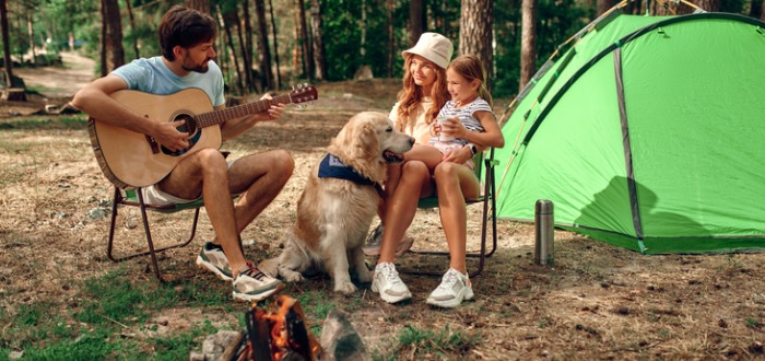 Familia con perro haciendo camping