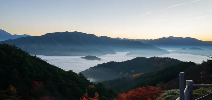 Vista de las montañas boscosas del Kumano Kodo con niebla matinal y colores de otoño, ilustrando la mejor época del año para recorrerlo.